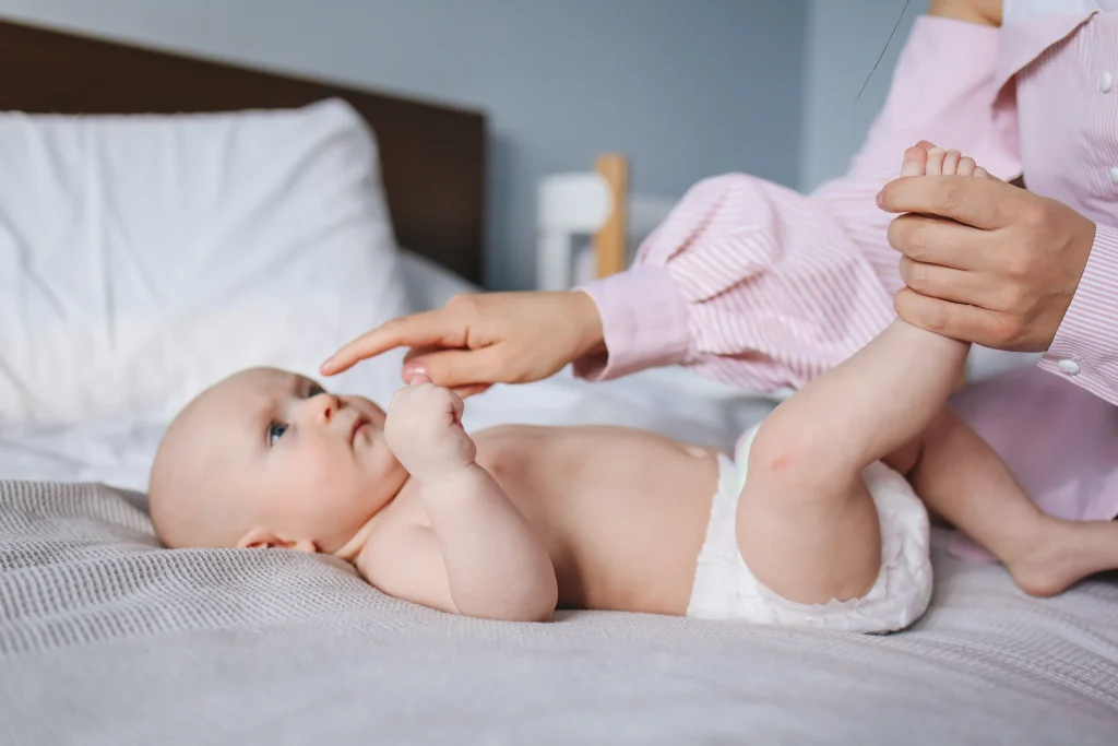 A mother with her baby on a bed.