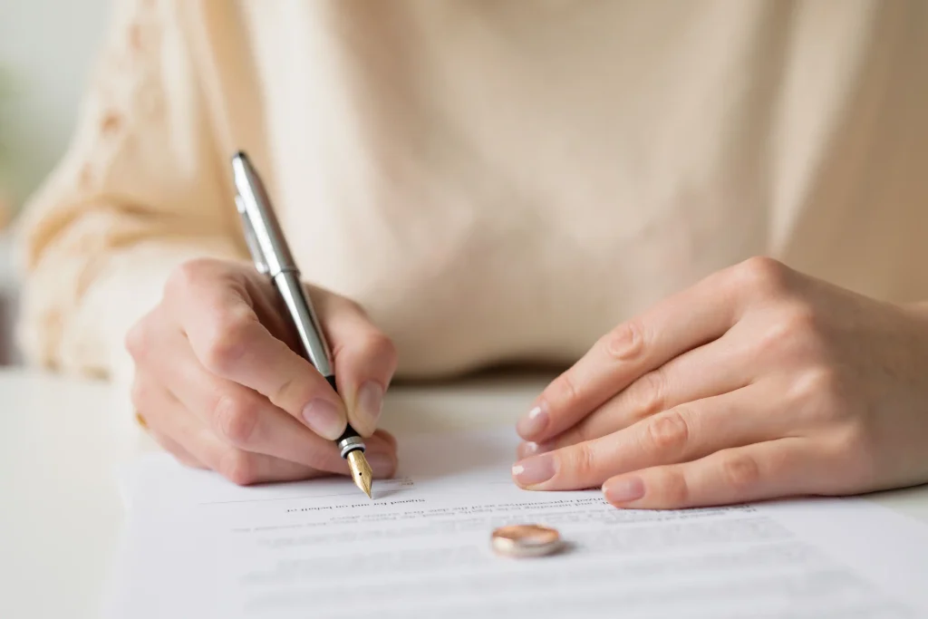 A woman signing divorce papers.