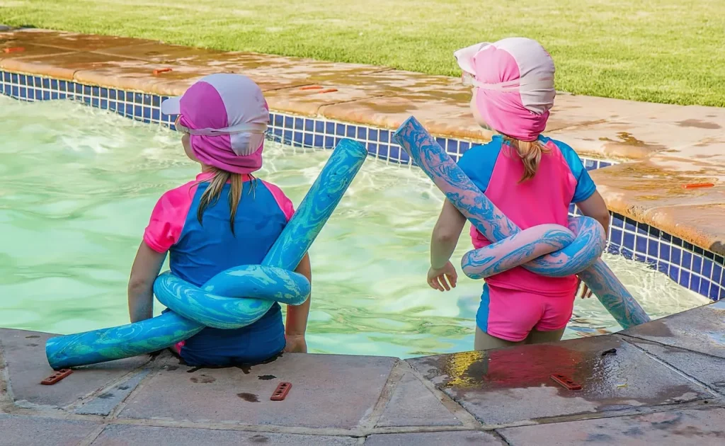 Children sitting near a pool.